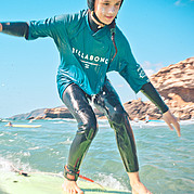 Ragazza surfista che scivola su una piccola onda verde