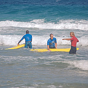 Surf istruttore spiega la postion corretta sulla tavola da surf